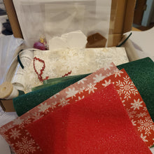 Load image into Gallery viewer, Close-up of fabric swatches including red, green, and patterned fabric contents of a EPP kit.
